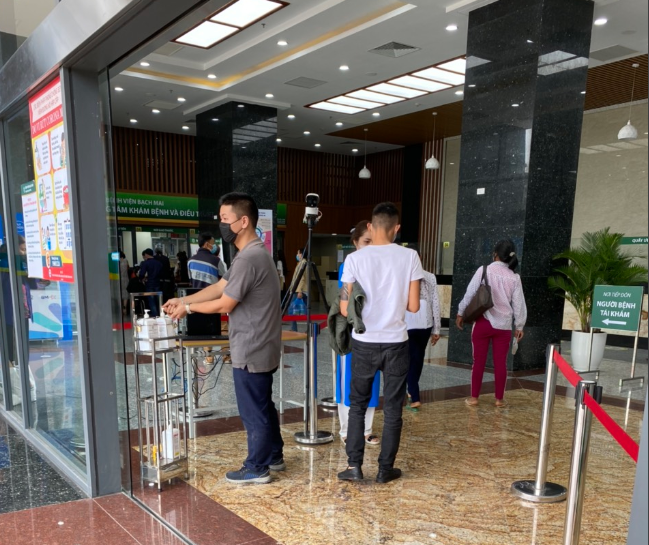 Tại khu khám bệnh khác của Bệnh viện Bạch Mai, ngay từ cửa, người đến khám cũng phải thực hiện sát khuẩn và khai báo y tế đầy đủ. Bệnh viện cũng trang bị thiết bị điện tử kiểm tra thân nhiệt. Ảnh: L.A.
