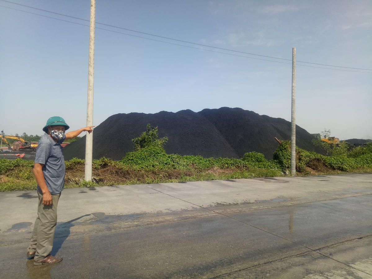 Người dân chỉ vào đống than cao như núi.