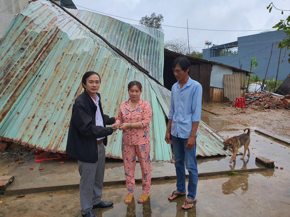 Tiến sĩ Lê Văn Nho trao quà cho người dân có nhà bị sập.