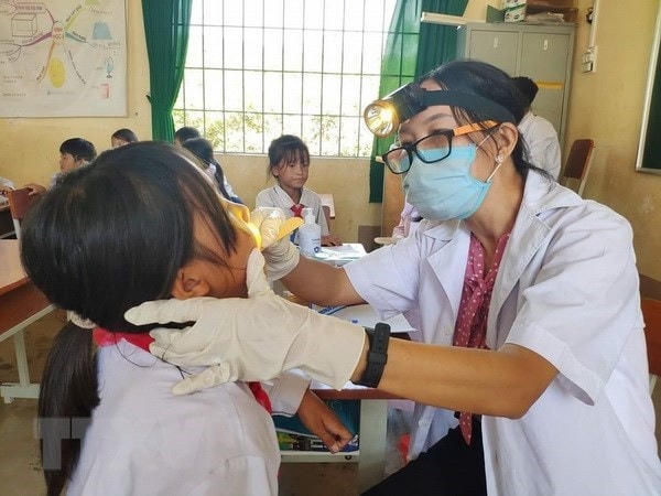 Cán bộ y tế  kiểm tra dịch tễ, lấy mẫu ngoáy họng để xét nghiệm cho các học sinh.