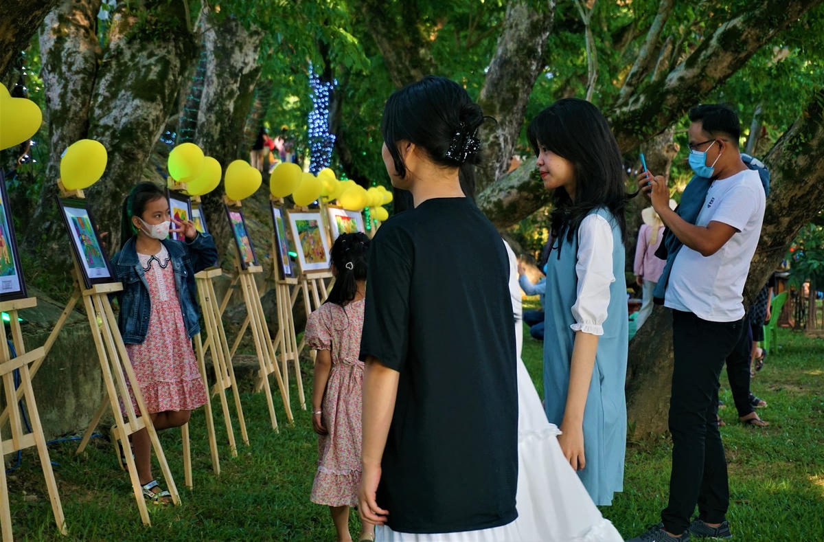 Các cháu thiếu nhi xem trưng bày triển lãm ảnh về TP Tam Kỳ.