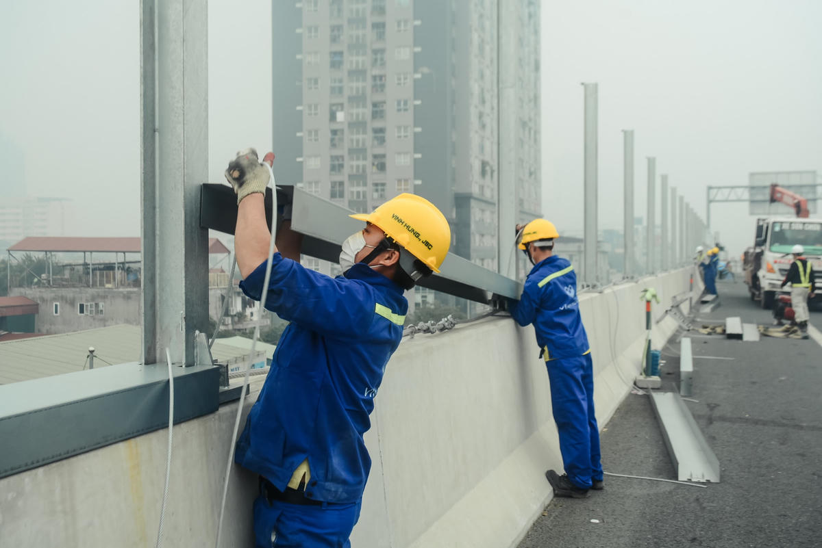 Công nhân lắp đặt các máng sắt nhằm kết nối các trụ với nhau. Bên cạnh đó, máng sắt còn làm mặt phẳng để lắp các tấm chống ồn, đảm bảo sự chắc chắn vừa mang thẩm mỹ cho tuyến đường Vành Đai 3 trên cao.