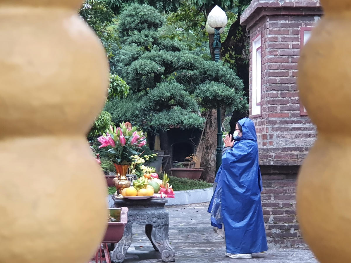 Dù thời tiết mưa rét, nhiều người vẫn thành tâm khấn vái, mong muốn sang năm mới vạn sự bình an.