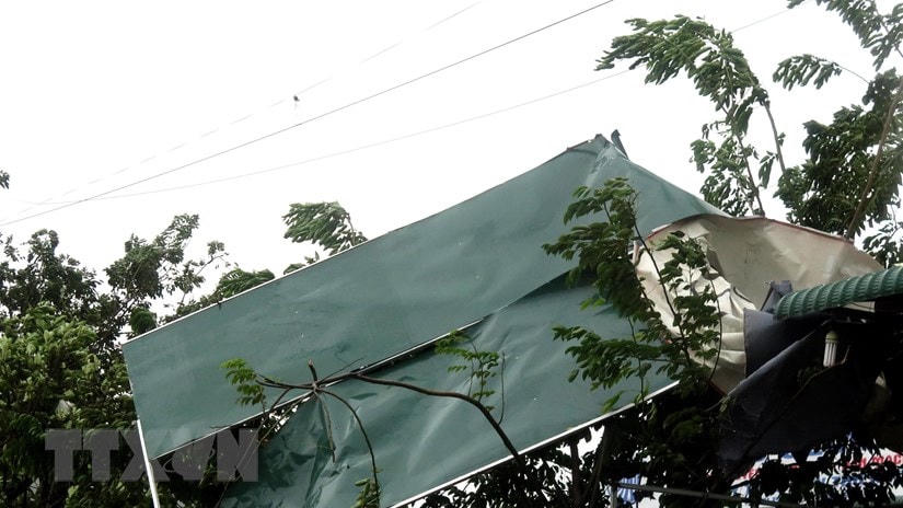 Nhiều mái tôn tại nhà dân bị gió cuốn phăng. (Ảnh: Lê Ngọc Phước/TTXVN).
