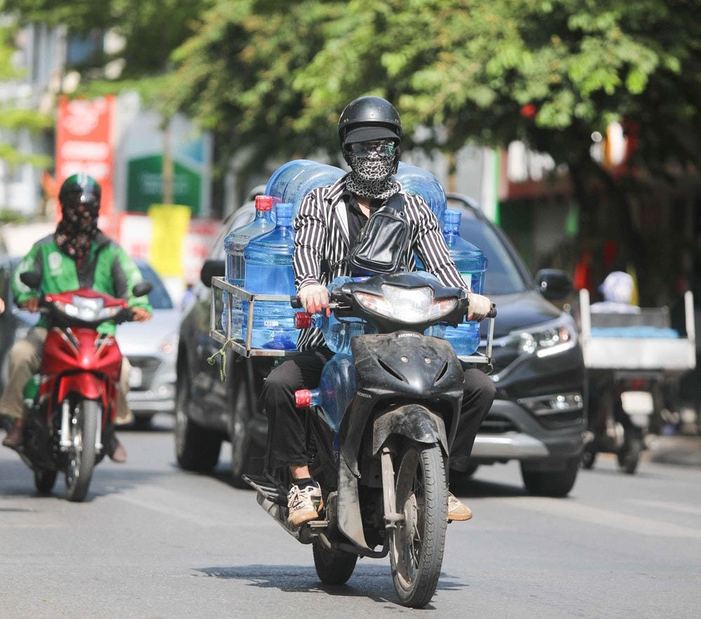 Thời tiết nắng nóng, tia UV ở mức cao, người dân cần trang bị tốt đồ bảo hộ khi ra đường để bảo vệ sức khỏe. Ảnh: TTXVN.