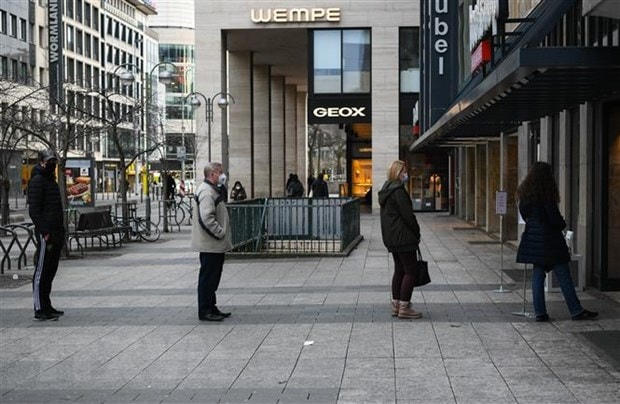 Người dân thực hiện giãn cách xã hội tại một cửa hàng sách ở Frankfurt, Đức nhằm ngăn dịch Covid-19 lây lan. (Ảnh: THX/TTXVN).