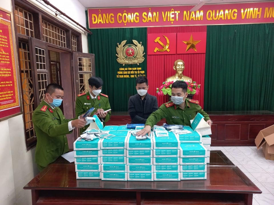Tuyên (áo đen) cùng tang vật hàng lậu.