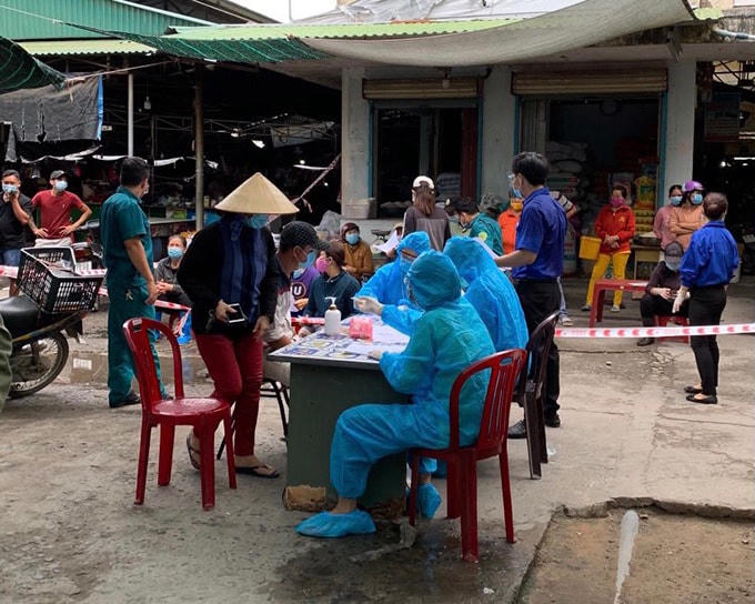 Lực lượng chức năng lấy mẫu xét nghiệm cho các tiểu thương chợ Cam Lộc, TP Cam Ranh.