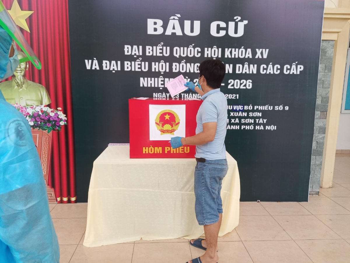 Người dân nhận phiếu cử tri, phiếu bầu, bầu xong bỏ vào thùng phiếu, sau đó bỏ thước, bút, găng tay vào thùng rác và đi về phòng. Ảnh: Đại uý Lê Đức Thiện.