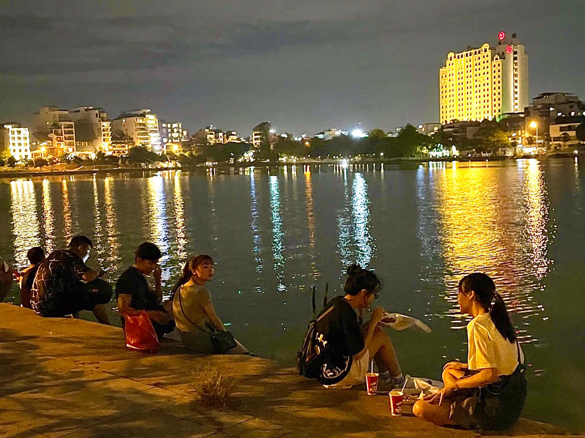 Các hàng quán vẫn chưa được mở bán trực tiếp nên không ít bạn trẻ mang đồ ăn ra bờ hồ hóng gió.