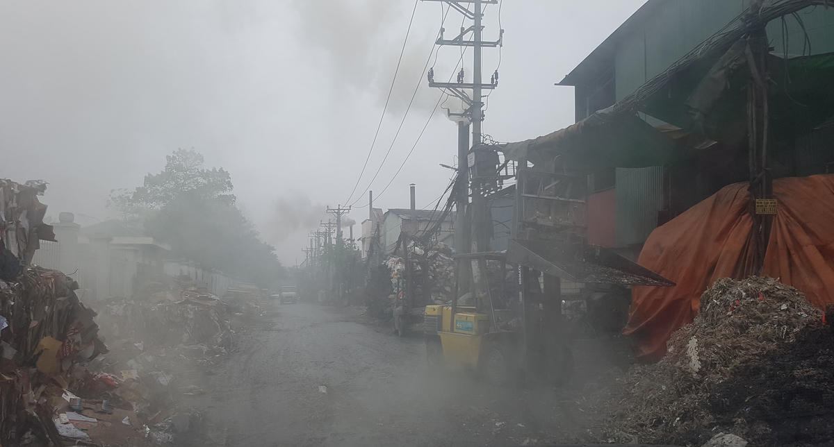 Môi trường làng nghề giấy Phong Khê lúc gần trưa, bụi khói như sương mù. Ảnh: Hà An.