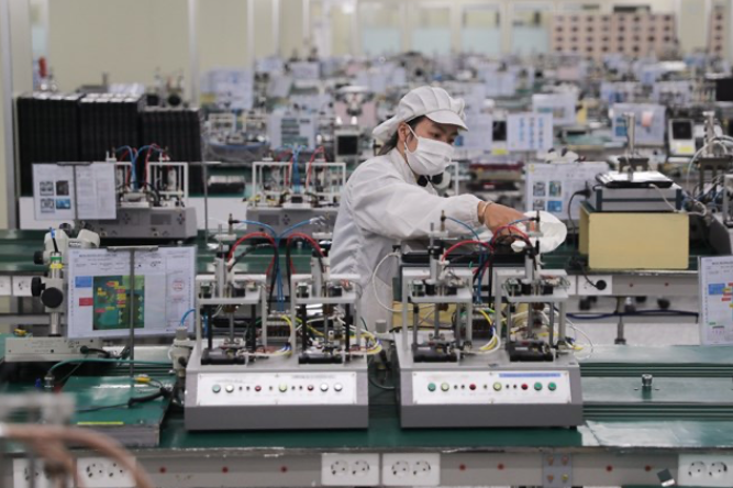 Công nhân Công ty Hosiden lau máy móc, chuẩn bị cho hoạt động trở lại sản xuất sau thời gian ngừng hoạt động để phòng, chống dịch Covid-19. Ảnh: Quang Vinh. 