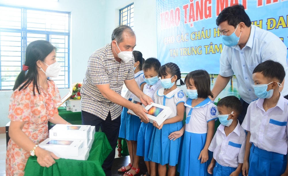 Phó Chủ tịch Thường trực UBND tỉnh Trần Hoàng Tuấn trao máy tính cho các em học sinh.