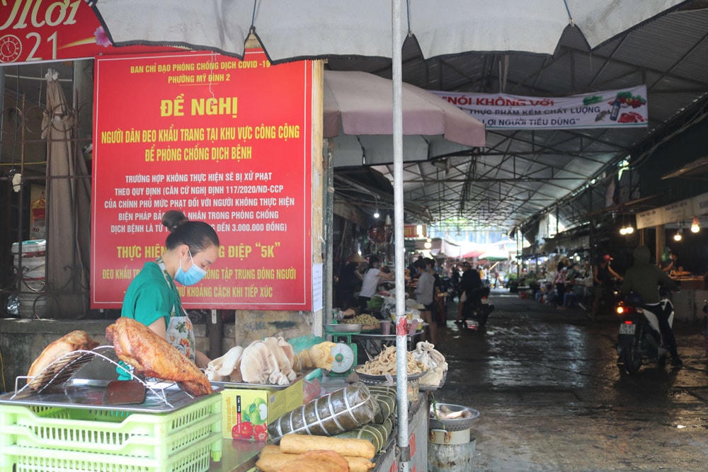 Biển báo nhắc nhở người dân đeo khẩu trang phòng dịch được bố trí trước cổng chợ Mỹ Đình.