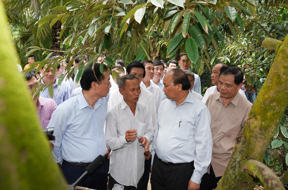 Thủ tướng Nguyễn Xuân Phúc thăm mô hình sản xuất sầu riêng của ông Mai Văn Âu. Ảnh: VGP/Quang Hiếu.