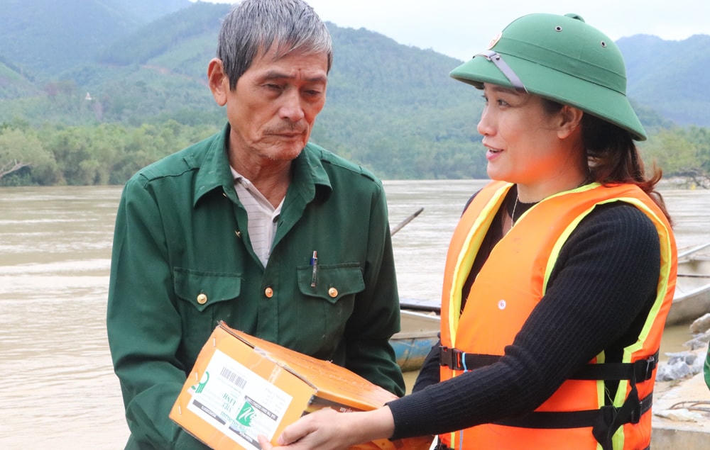 Phó Chủ tịch Ủy ban MTTQ Việt Nam thị xã Ba Đồn (tỉnh Quảng Bình) Trần Thị Tuyết Lan trao hỗ trợ người dân ở vùng cồn bãi sông Gianh.