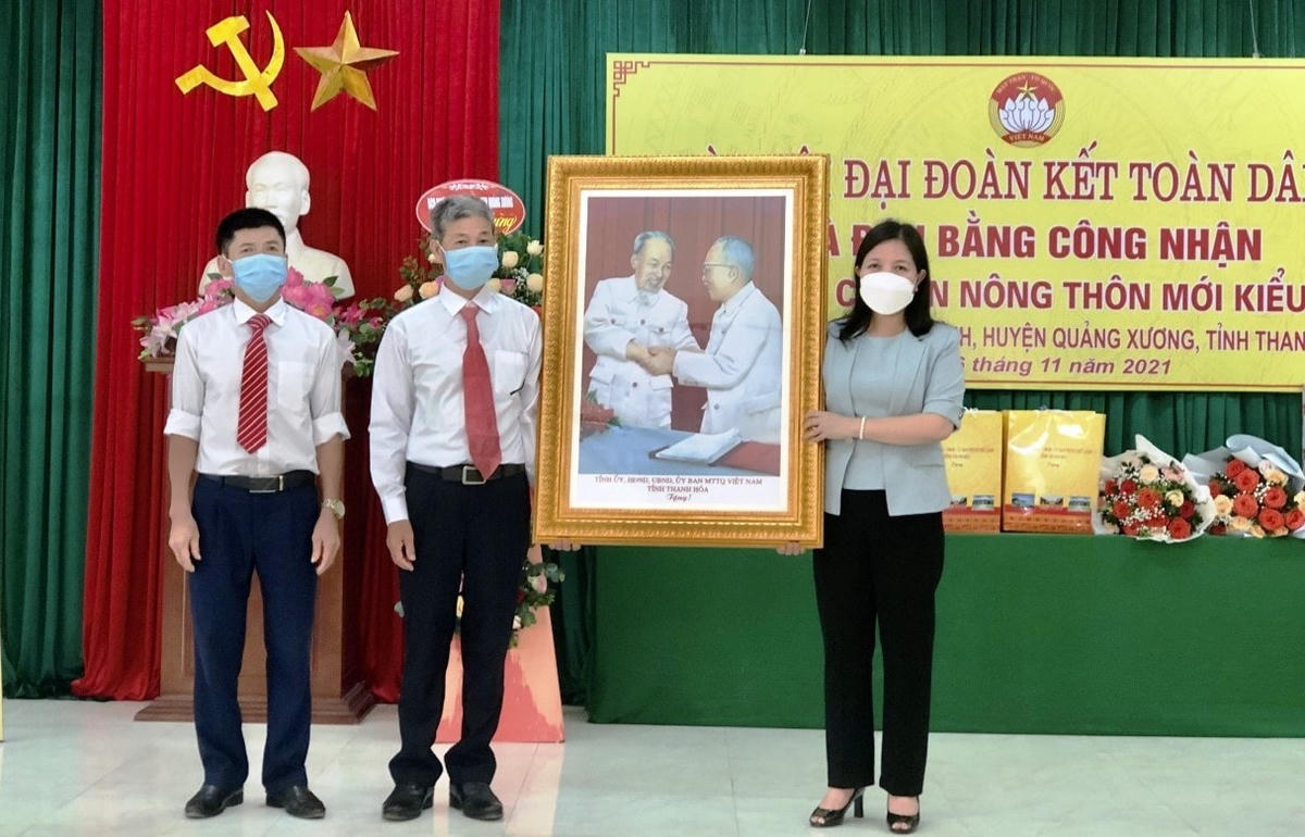 Bà Phạm Thị Thanh Thủy trao bức hình lưu niệm Bác Hồ và Bác Tôn cho cán bộ và nhân dân thôn Xa Thư.