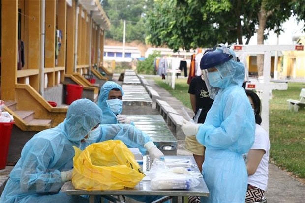 Lấy mẫu xét nghiệm SARS-CoV-2 cho các công dân trong khu vực cách ly. Ảnh: TTXVN.