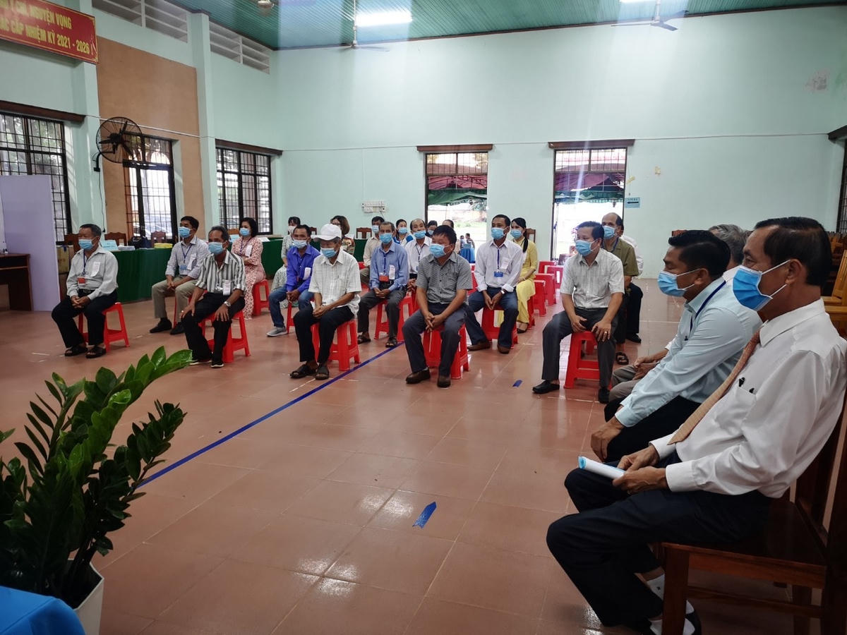 Cử tri thực hiện giãn cách chỗ ngồi khi đi bầu cử tại một điểm bỏ phiếu ở TX Phú Mỹ.
