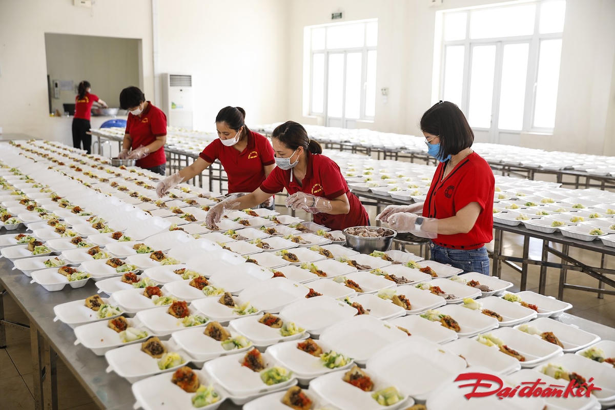 Các chị em bước vào việc chia cơm, thức ăn thành các suất. Đây là công đoạn lâu nhất vì số lượng suất ăn mỗi bữa khá lớn. Ảnh: Quang Vinh. 