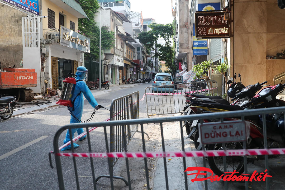 Nơi ở của 5 ca dương tính liên quan TP Hồ Chí Minh tại phố Bùi Thị Xuân, phường Nguyễn Du, quận Hai Bà Trưng, Hà Nội được dựng rào chắn, thực hiện phun khử khuẩn toàn bộ. Ảnh: Quang Vinh. 