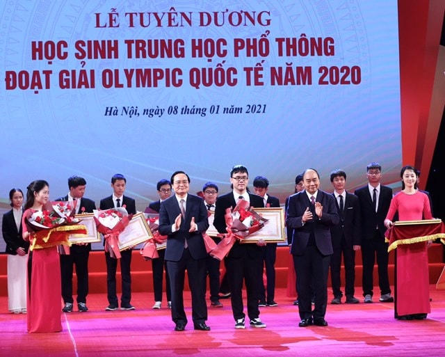 Thủ tướng Nguyễn Xuân Phúc, Chủ tịch Hội đồng Thi đua - Khen thưởng Trung ương và Bộ trưởng Bộ GDĐT Phùng Xuân Nhạ trao Huân chương Lao động cho các em học sinh THPT đoạt giải Olympic quốc tế 2020.  