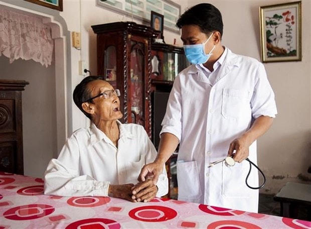 Bác sĩ Danh Ngọc Châu thăm hỏi bệnh tình ông Trịnh Ghế (78 tuổi), ấp Sua Đũa, xã Vĩnh Hòa Hiệp, huyện Châu Thành. (Ảnh: Hồng Đạt/TTXVN)  