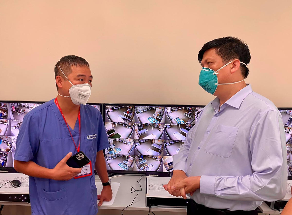 PGS TS Nguyễn Lân Hiếu báo cáo với Bộ trưởng về công tác điều trị tại Trung tâm Hồi sức Covid-19 đặt tại Bệnh viện Becamex. Ảnh: Bộ Y tế