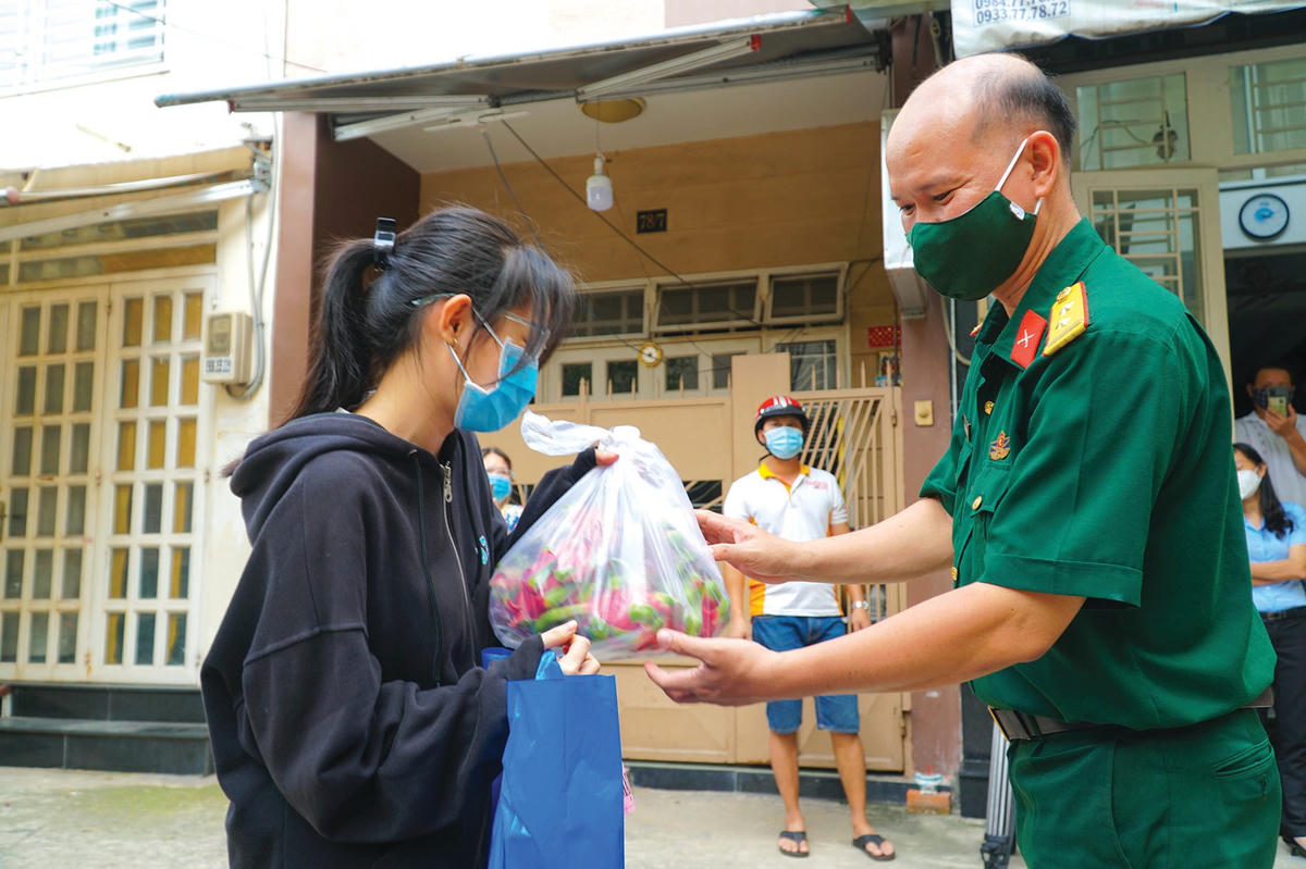 Trung tá Nguyễn Thanh Tâm, Chính trị viên Ban CHQS Quận 5 tặng quà động viên các sinh viên đang gặp khó khăn tại TP HCM.
