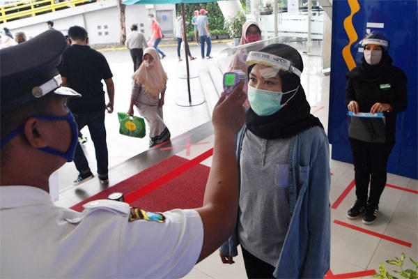 Kiểm tra sức khỏe của người đi siêu thị tại Surabaya (Đông Java, Indonesia). Ảnh: Antara.