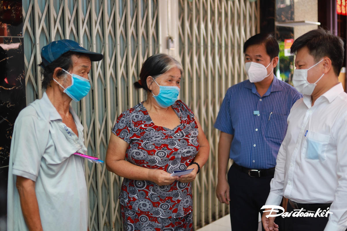 Ông Nguyễn Mạnh Cường, Bí thư Quận ủy Quận 5 (áo trắng); ông Lê Tấn Tài, Chủ tịch Ủy ban MTTQ Việt Nam Quận 5 (áo sọc xanh) động viên một trường hợp bảo vệ dân phố.