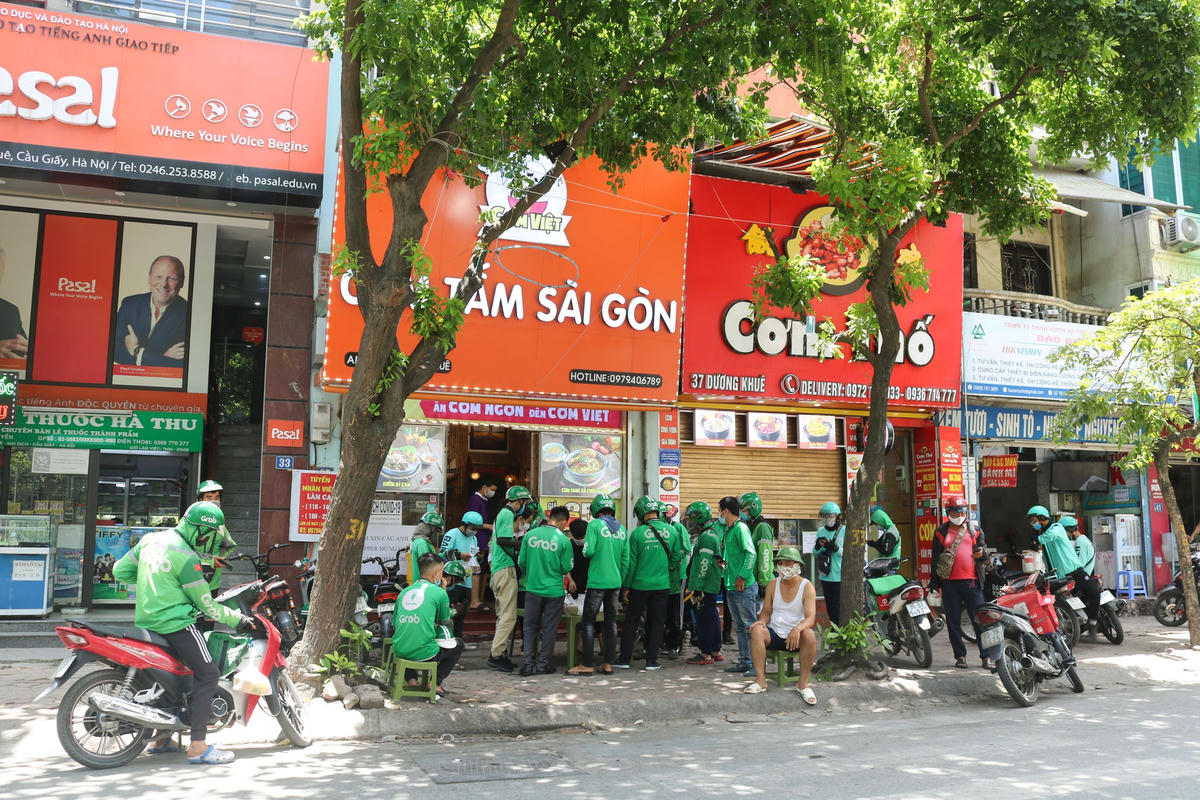 Giờ cao điểm, không khó để bắt gặp hình ảnh shipper xếp hàng dài để nhận đồ tại các quán hàng.