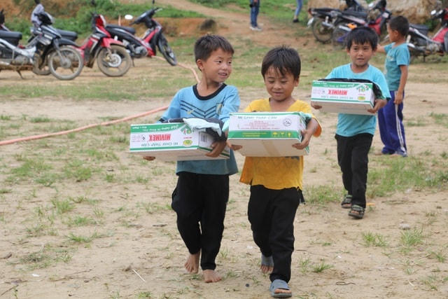Học sinh nghèo háo hức nhận những suất quà.  