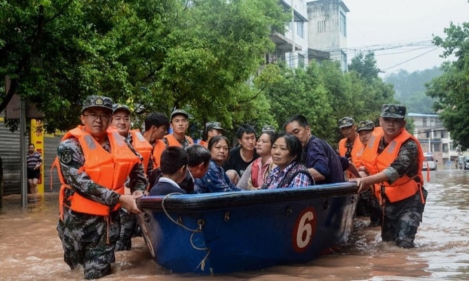 Quân đội Trung Quốc sơ tán người dân khỏi vùng ngập lũ ở thành phố Trùng Khánh hôm 1/7. Ảnh: AFP.
