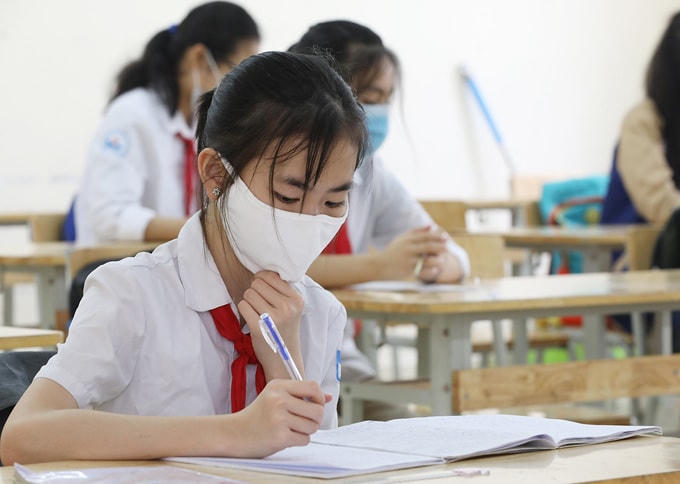 Học sinh trường THCS Nguyễn Du (Nam Từ Liêm, Hà Nội) đeo khẩu trang, đo nhiệt độ trong ngày trở lại trường đầu tiên sau nhiều tháng nghỉ học năm 2020. Ảnh: Ngọc Thành.