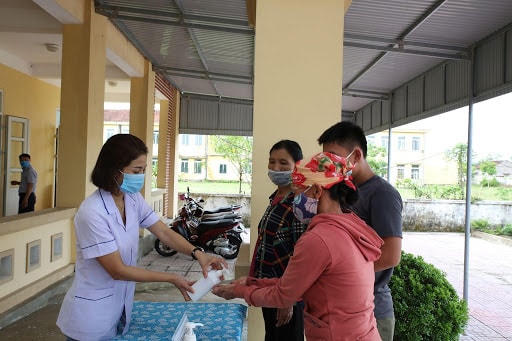 Người dân được nhân viên y tế cơ sở hướng dẫn các biện pháp thực hành phòng, chống dịch Covid-19. Ảnh: Tuấn Dũng.