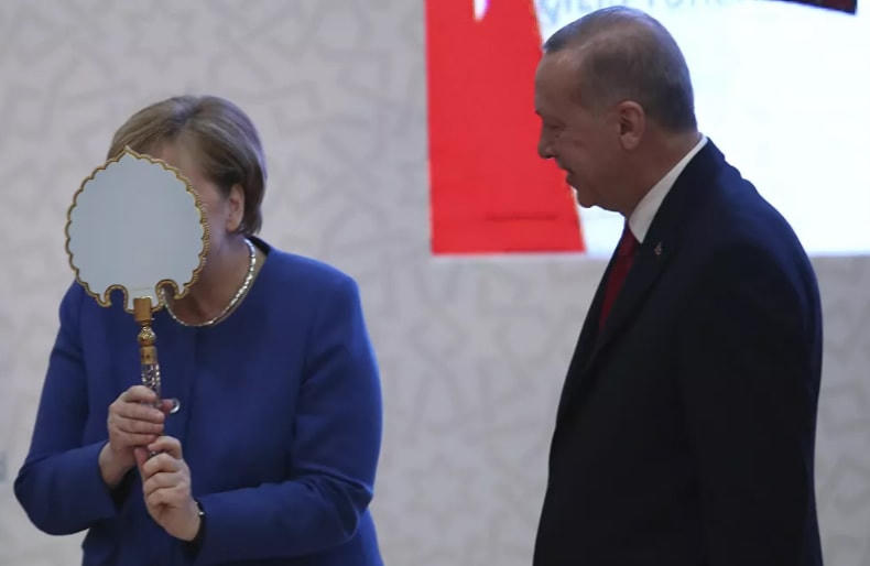 Thủ tướng Đức Angela Merkel có hành động hài ước khi nhận một tấm gương do Tổng thống Thổ Nhĩ Kỳ Recep Tayyip Erdogan tặng trong lễ khai trương cơ sở mới của một trường đại học Thổ Nhĩ Kỳ-Đức, ở Istanbul, năm 2020.  
