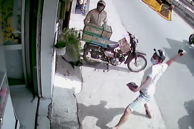 Nam thanh niên ném 2 bịch mắm tôm vào nhà bà Mai vào trưa ngày 1/3. Ảnh cắt từ clip.  