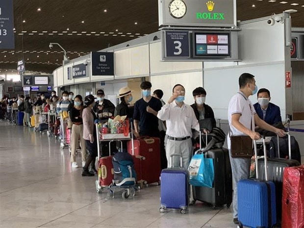 Công dân Việt Nam từ Pháp và các nước lân cận ở khu vực châu Âu làm thủ tục lên máy bay để về nước. (Ảnh: TTXVN).