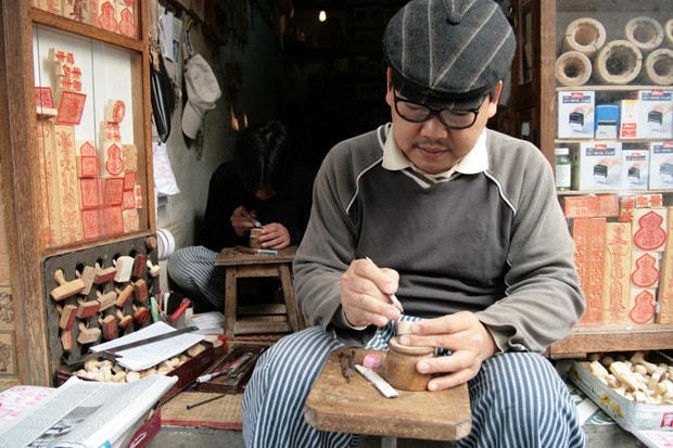 Chủ cửa hàng Phúc Lợi trên phố Hàng Quạt chuyên làm khuôn bánh, khuôn oản, khuôn xôi và những con dấu, con triện. (Ảnh: Lê Bích).