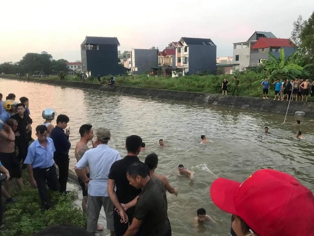 Người dân tìm kiếm 3 ông cháu tại tuyến kênh chảy qua thị trấn Hợp Hòa chiều 15/9. Ảnh: Dân trí.