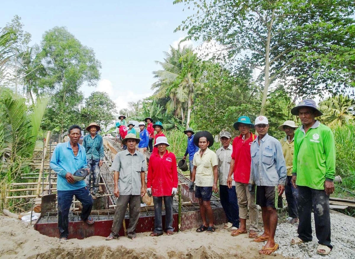 Ông Huỳnh Sa Vết  (thứ 3 từ phải qua) cùng người dân xây cầu.