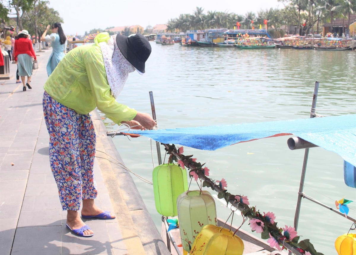 Bà Võ Thị Khai đang chỉnh sửa lại chiếc ghe.