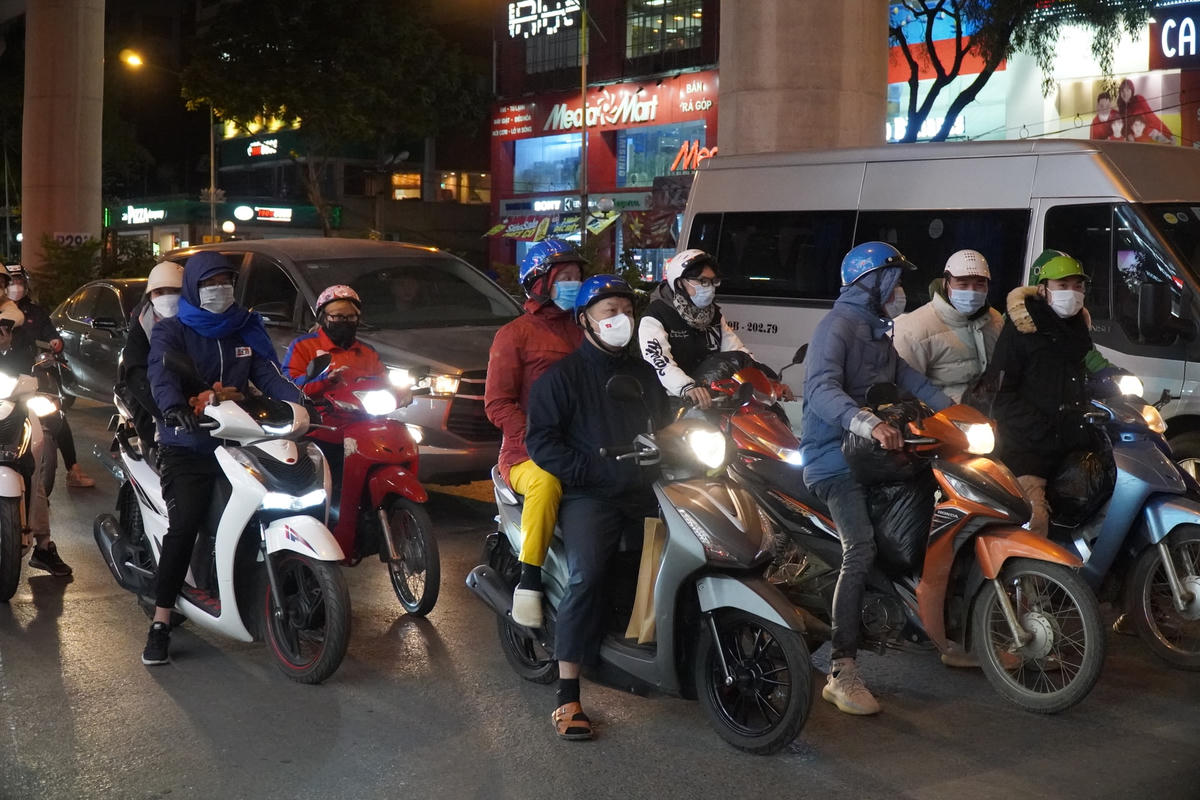 Người đi đường co ro trong lúc đợi đèn đỏ.