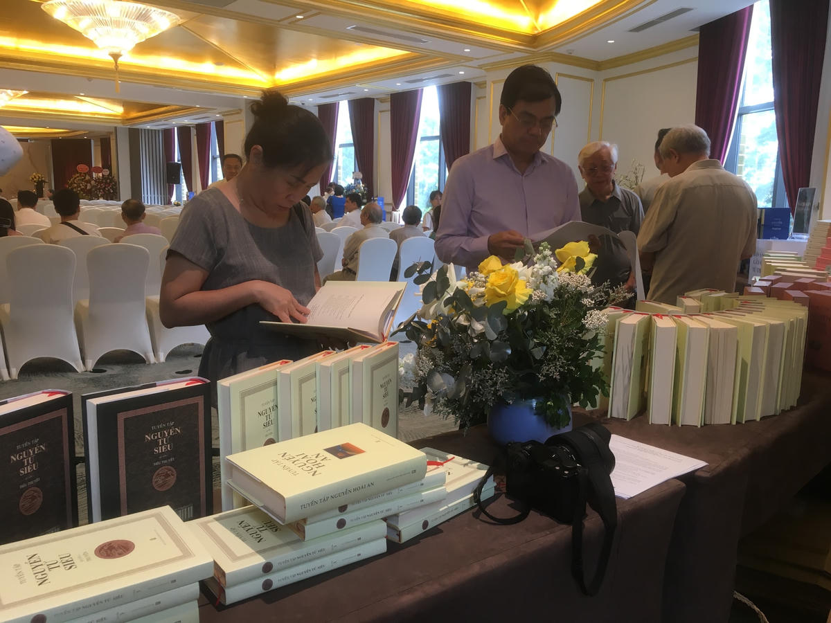 Khách mời xem sách trước giờ khai mạc.