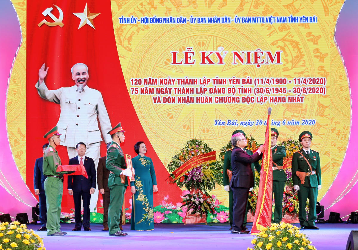 Thường trực Ban Bí thư Trần Quốc Vượng thay mặt Đảng và Nhà nước gắn Huân chương Độc lập hạng Nhất lên quốc kỳ trao tặng cho tỉnh Yên Bái sáng nay (30/6).