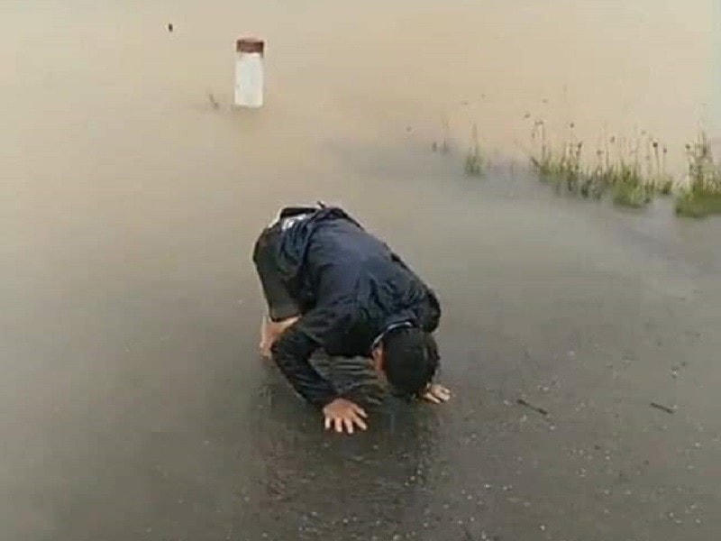 Người chồng quỳ khóc tại nơi người vợ bị nước cuốn trôi.