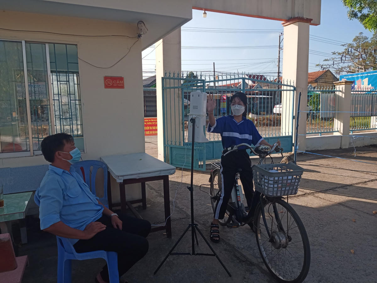 Học sinh được đo thân nhiệt và sát khuẩn trước khi vào trường.