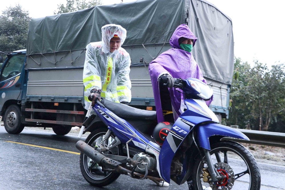 Lực lượng Cảnh sát giao thông giúp người dân di chuyển qua đoạn đường đóng băng. (Ảnh: Nguyễn Oanh/TTXVN).