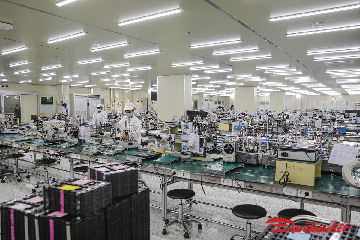 Các công nhân thực hiện lau chùi máy móc, trong quá trình làm việc công nhân đều thực hiện giữ khoảng cách và đeo khẩu trang đúng quy định. Ảnh: Quang Vinh. 